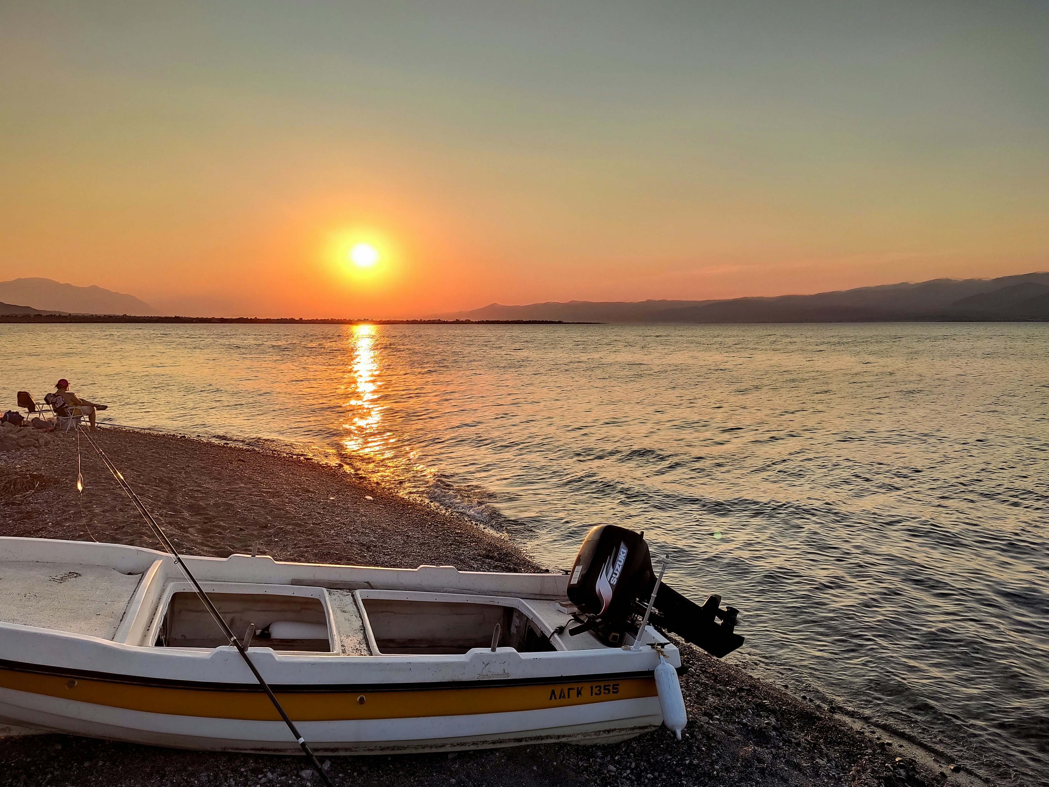 white and brown boat on sea shore during sunset